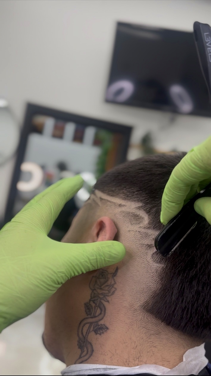 Dathan detailing a client’s haircut with clippers