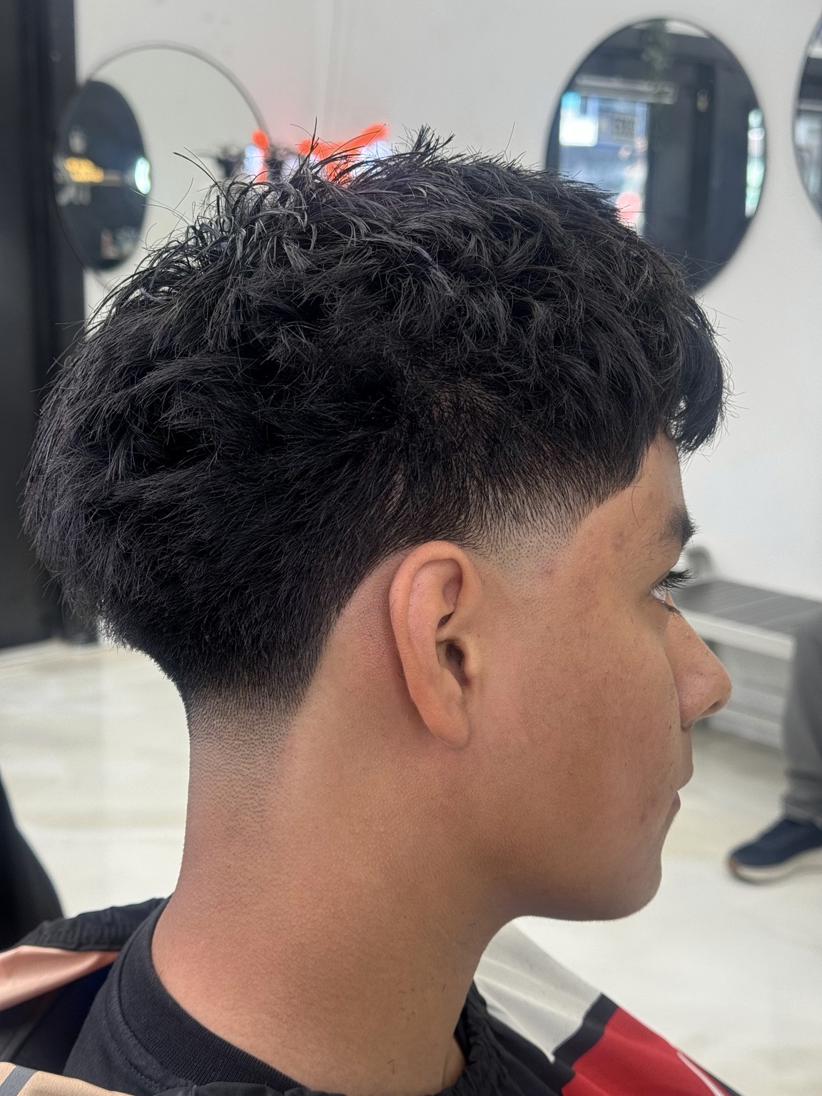 Client with dark textured hair and a clean fade
